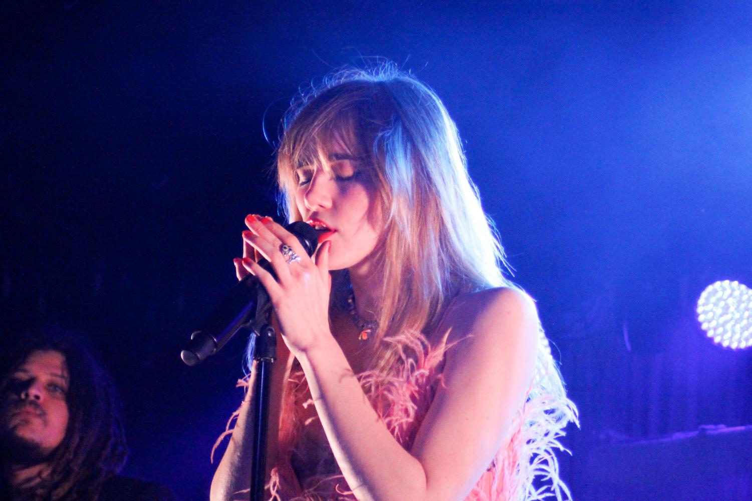 Suki Waterhouse performing on tour